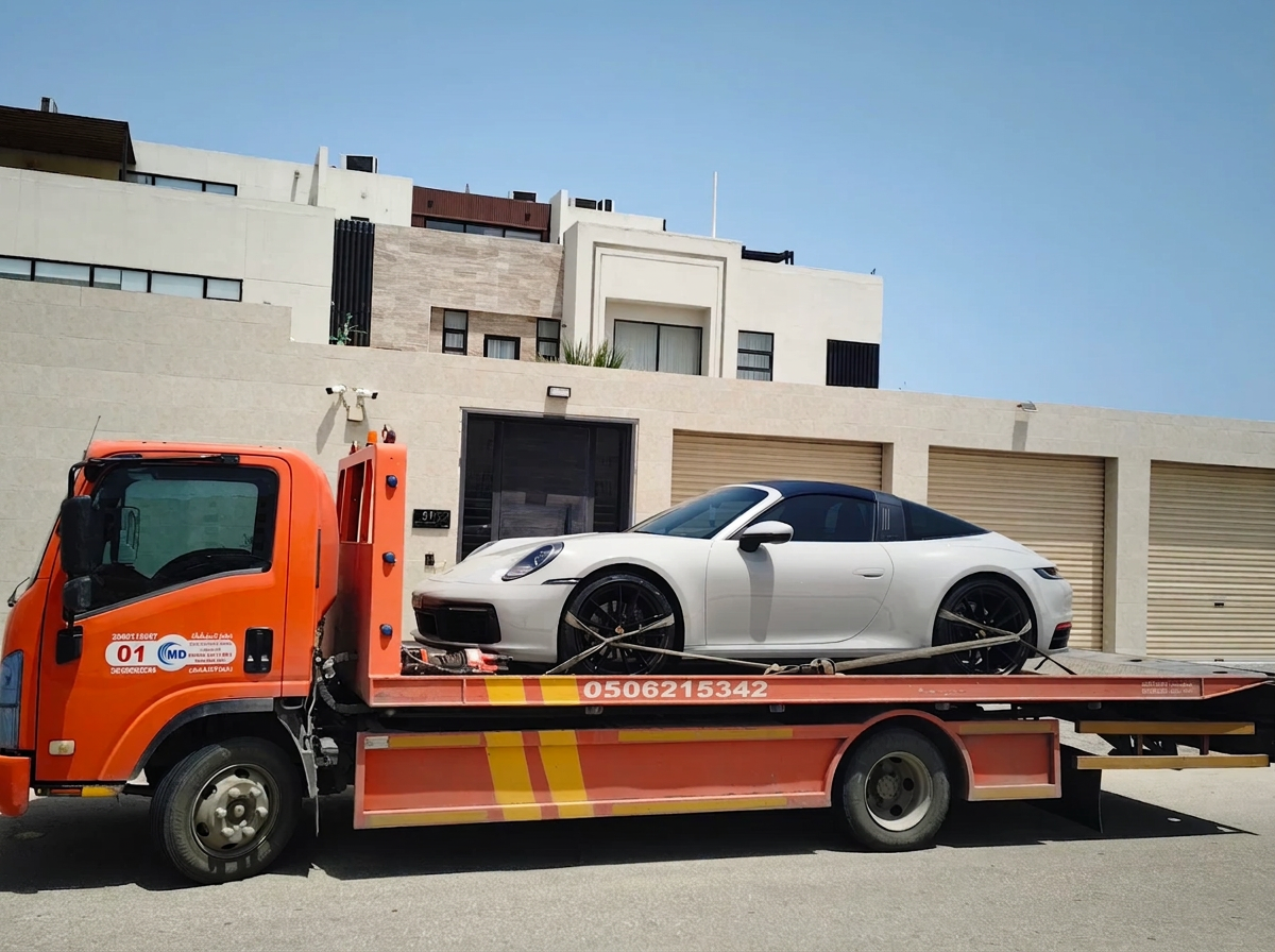 سطحة هيدروليك تنقل بورش 911 تارجا بيضاء أمام فيلا